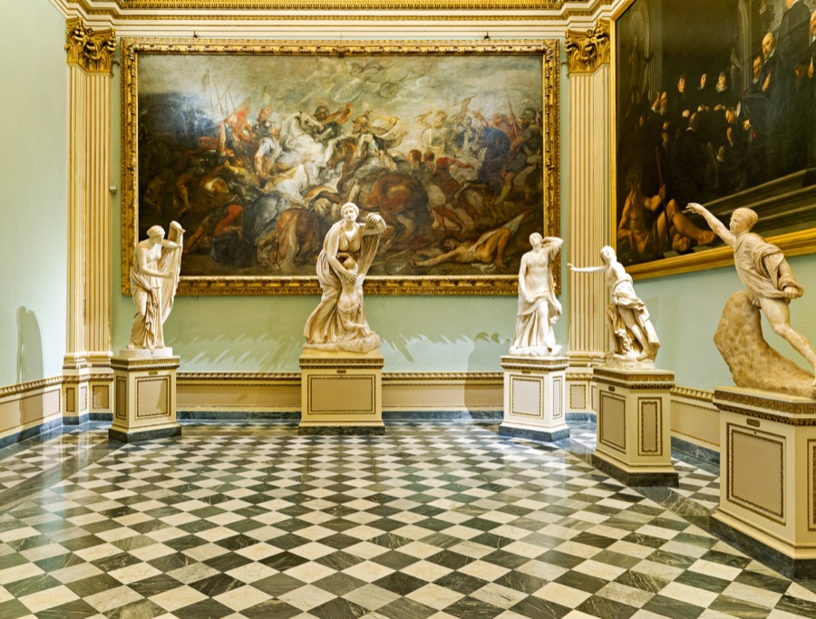A room in the Vatican Museums with paintings and sculptures